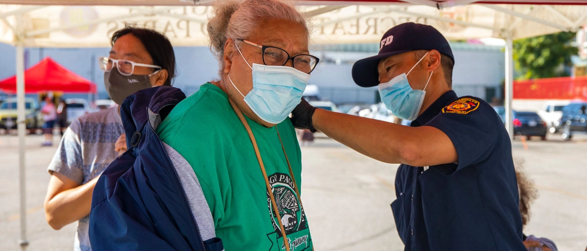 LAFD personnel administering vaccine to elderly patient