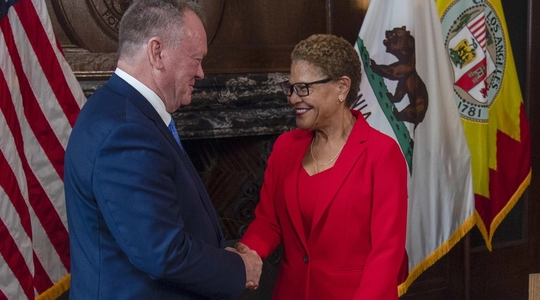 Mayor Karen Bass shaking hands with LAPD Chief Jim McDonnell