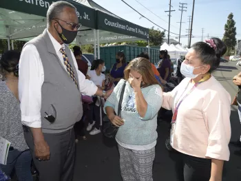 Councilmember Curren Price comforting a constituent