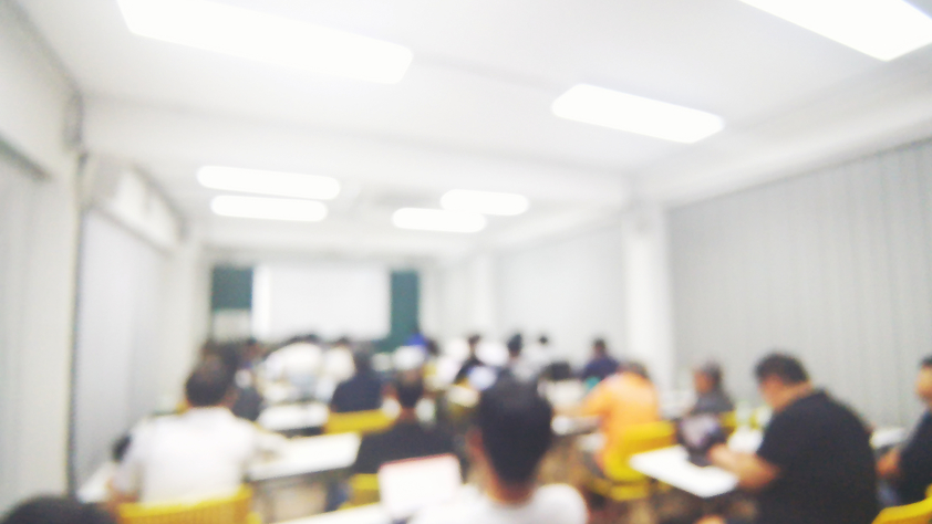 Blurred photo of meeting room with participants
